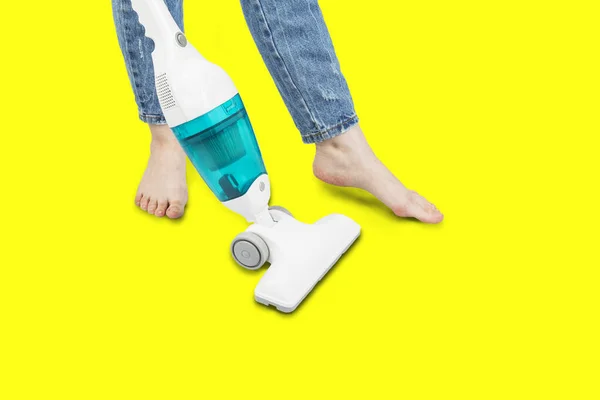 Portable vertical vacuum cleaner, girl vacuum cleaner, isolated on yellow background