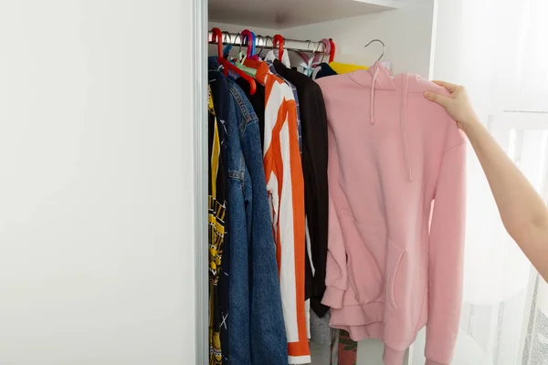 Woman Chooses Clothes Closet Takes Out Pink Hoody — Stock Photo, Image