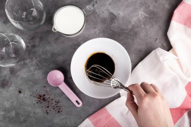 Popüler Kore Dalgon kahvesini adım adım pişiriyorum. Dördüncü adım, koyu gri arka planda çırpılmış kahve, şeker ve sıcak suyu çırpmaya başlar. Düz Yat, üst görünüm