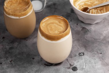 Popüler içecek Kore dargon kahvesi hazır kahve, şeker, sıcak su ve gri arka planda bardakta süt