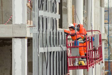 İnşaatçılar yükseklerde çalışıyorlar.