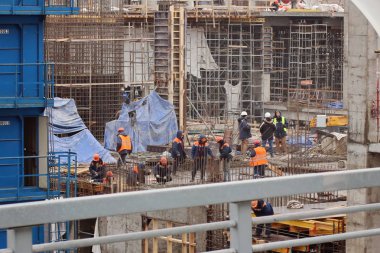 Miğferli inşaat işçileri inşaat alanında çalışıyor.