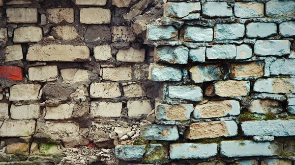 Multi-colored textured brick walls with a broken piece of the wall