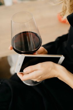 Telefon elinde tutarak şarap kadınla