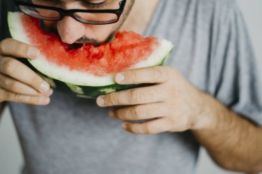 Genç adam karpuz yiyor 