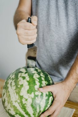 Genç adam bir karpuz keser