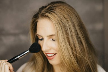 güzel bir genç kadın makyaj uygulamak 