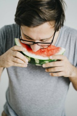 Genç adam karpuz yiyor 