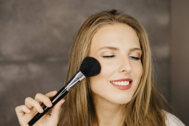 güzel bir genç kadın makyaj uygulamak 