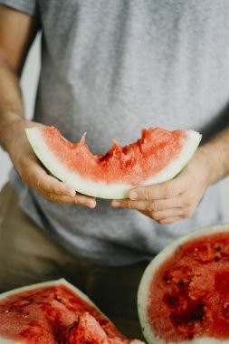 Genç adam karpuz tutar