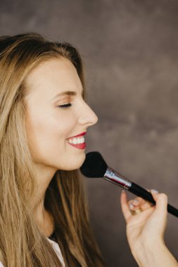 güzel bir genç kadın makyaj uygulamak 