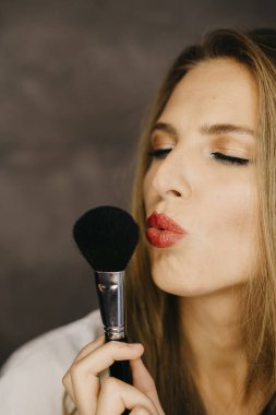 güzel bir genç kadın makyaj uygulamak 