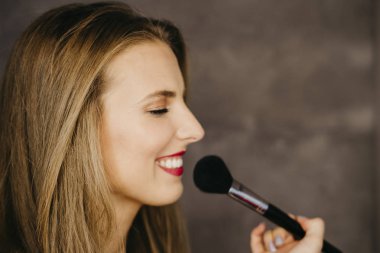 güzel bir genç kadın makyaj uygulamak 