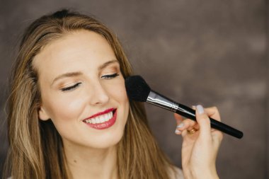 güzel bir genç kadın makyaj uygulamak 
