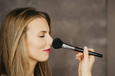güzel bir genç kadın makyaj uygulamak 