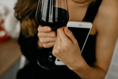 Telefon elinde tutarak şarap kadınla