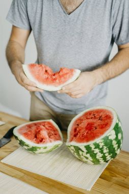 Genç adam karpuz tutar