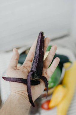 Vegan adam elinde siyah havuç