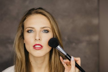 güzel bir genç kadın makyaj uygulamak 