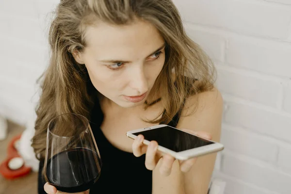 Telefon elinde tutarak şarap kadınla