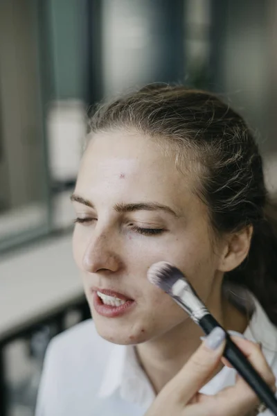 Young girl doing make-up in a salon