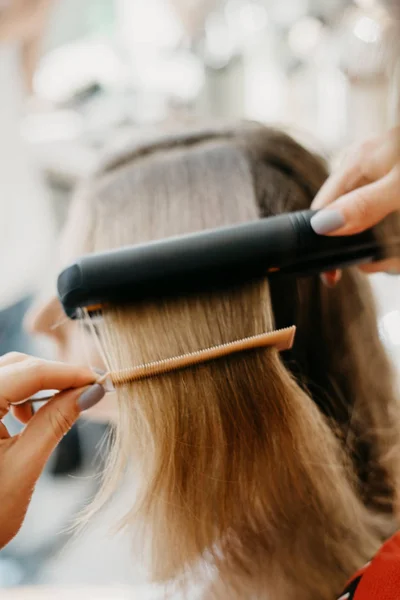 Girl makes hair styling in the salon