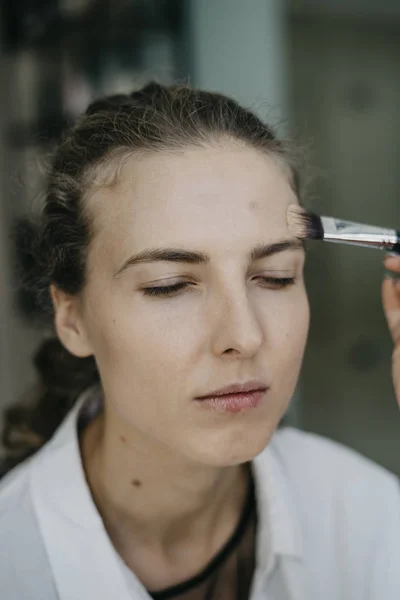 Young girl doing make-up in a salon