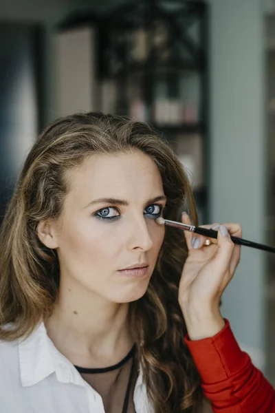 Chica joven haciendo maquillaje en un salón —  Fotos de Stock