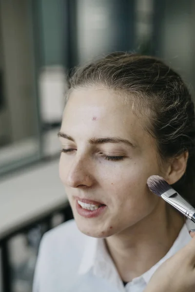 Young girl doing make-up in a salon