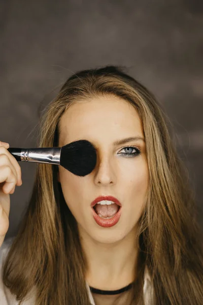 güzel bir genç kadın makyaj uygulamak 