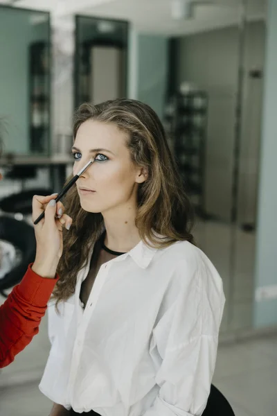 Chica joven haciendo maquillaje en un salón —  Fotos de Stock