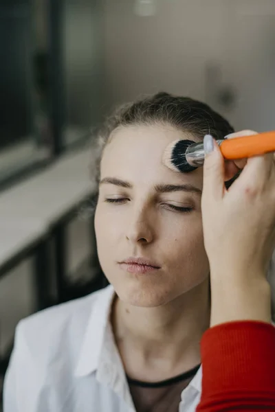 Young girl doing make-up in a salon