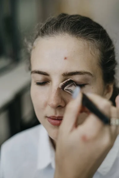 Young girl doing make-up in a salon