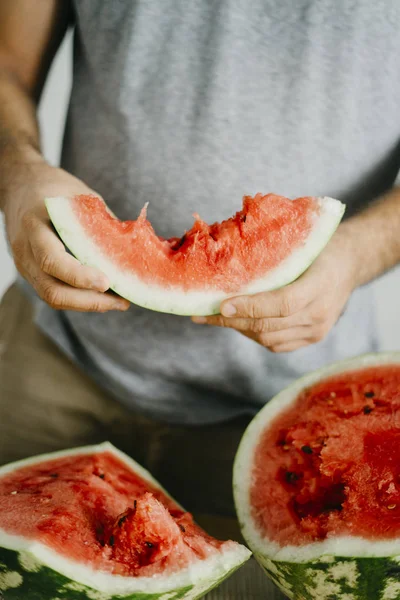 Genç adam karpuz tutar