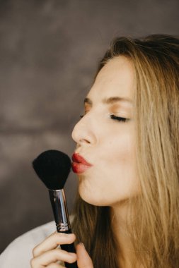 güzel bir genç kadın makyaj uygulamak 