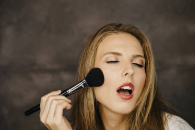 güzel bir genç kadın makyaj uygulamak 