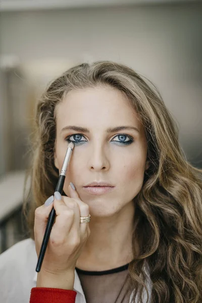 Young girl doing make-up in a salon