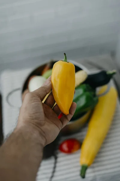Yellow pepper in vegan man hand