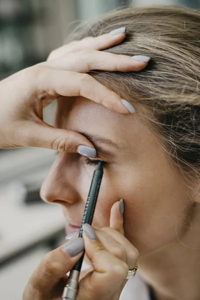 Jong meisje doet make-up in een salon — Stockfoto