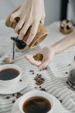 Mutfakta bir kahve değirmeni tutan kadın