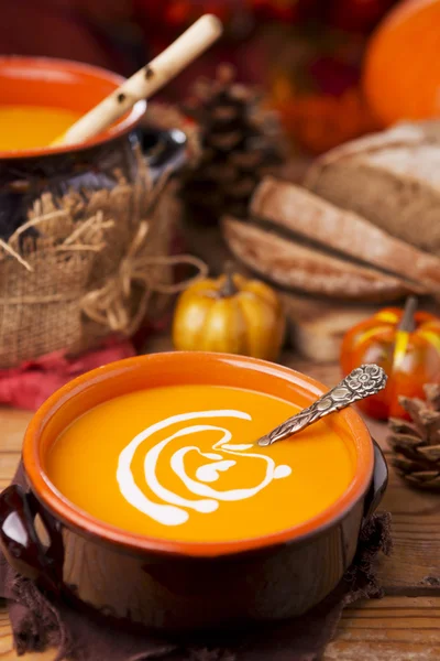 Soupe de citrouille maison sur une table rustique avec des décorations d'automne — Photo