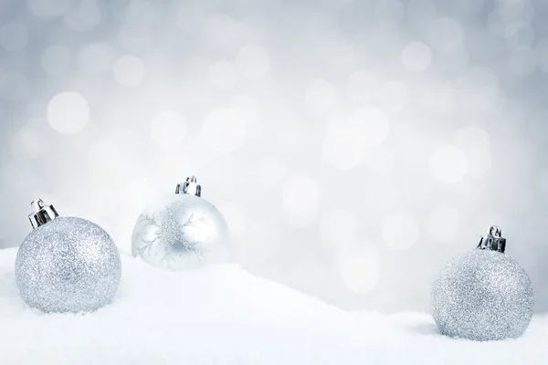 A hó egy ezüst hátterű ezüst karácsonyi baubles — Stock Fotó