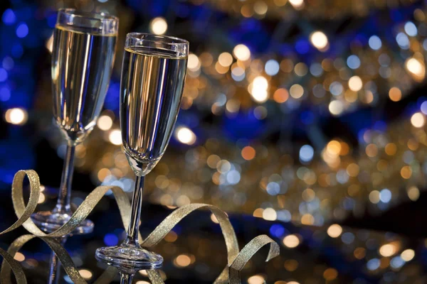 Copas de champán con luces de Navidad en el fondo — Foto de Stock