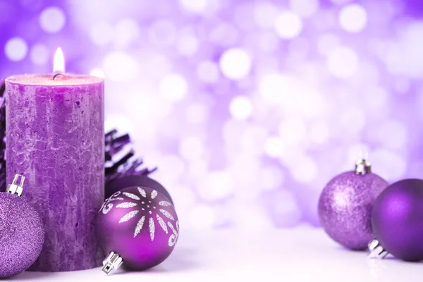 Escena navideña púrpura con adornos y velas — Foto de Stock