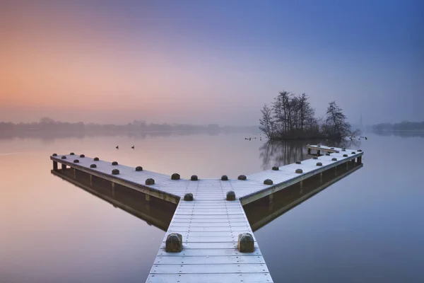 Steiger op een nog meer op een mistige winter ochtend — Stockfoto