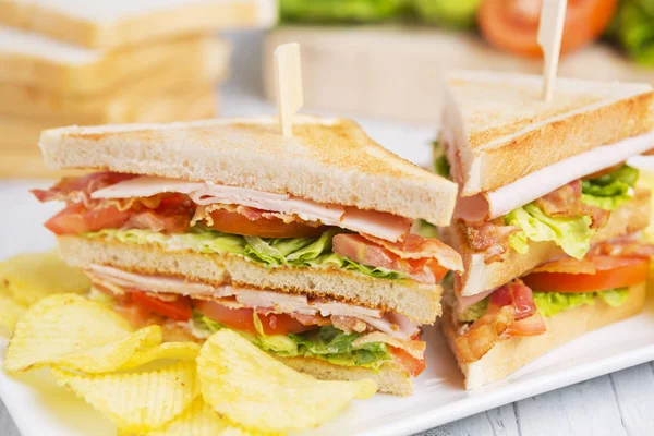 Club-Sandwich auf rustikalem Tisch im hellen Licht — Stockfoto