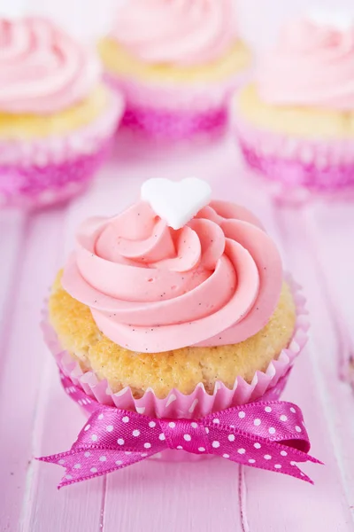 Rosa alla hjärtans cupcakes på ett rustikt rosa bord — Stockfoto