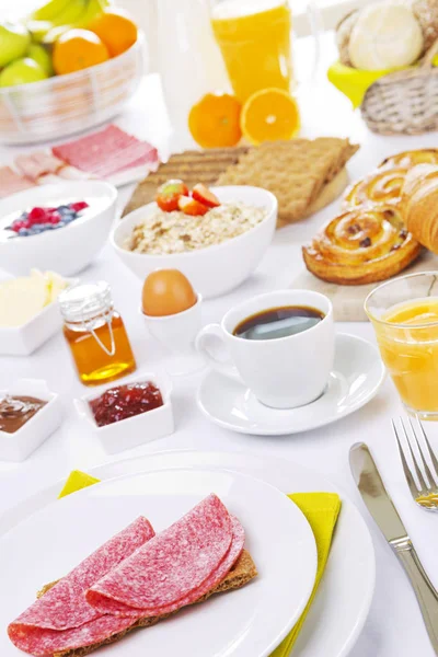 Mesa llena de platos de desayuno continental, muy iluminada — Foto de Stock