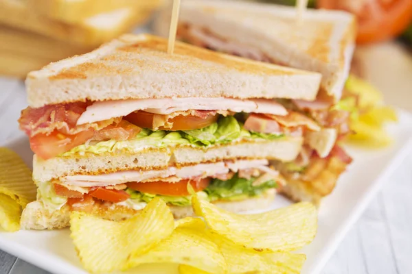 Club-Sandwich auf rustikalem Tisch im hellen Licht — Stockfoto