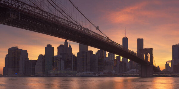 Brooklyn Bridge with the New York City skyline in the background, photographed at sunset.